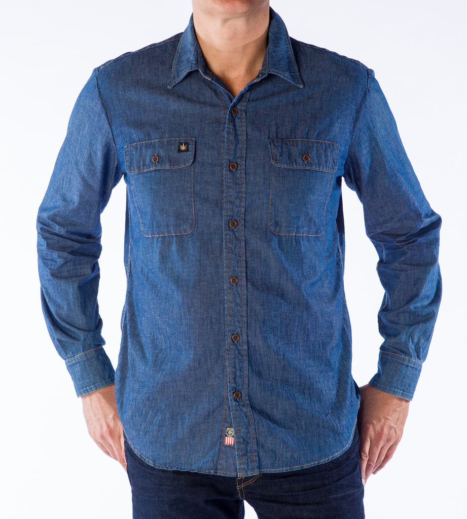 A man wearing a medium HempBlue sustainable organic cotton blue denim long sleeve buttondown shirt with a HempBlue patch on the chest.