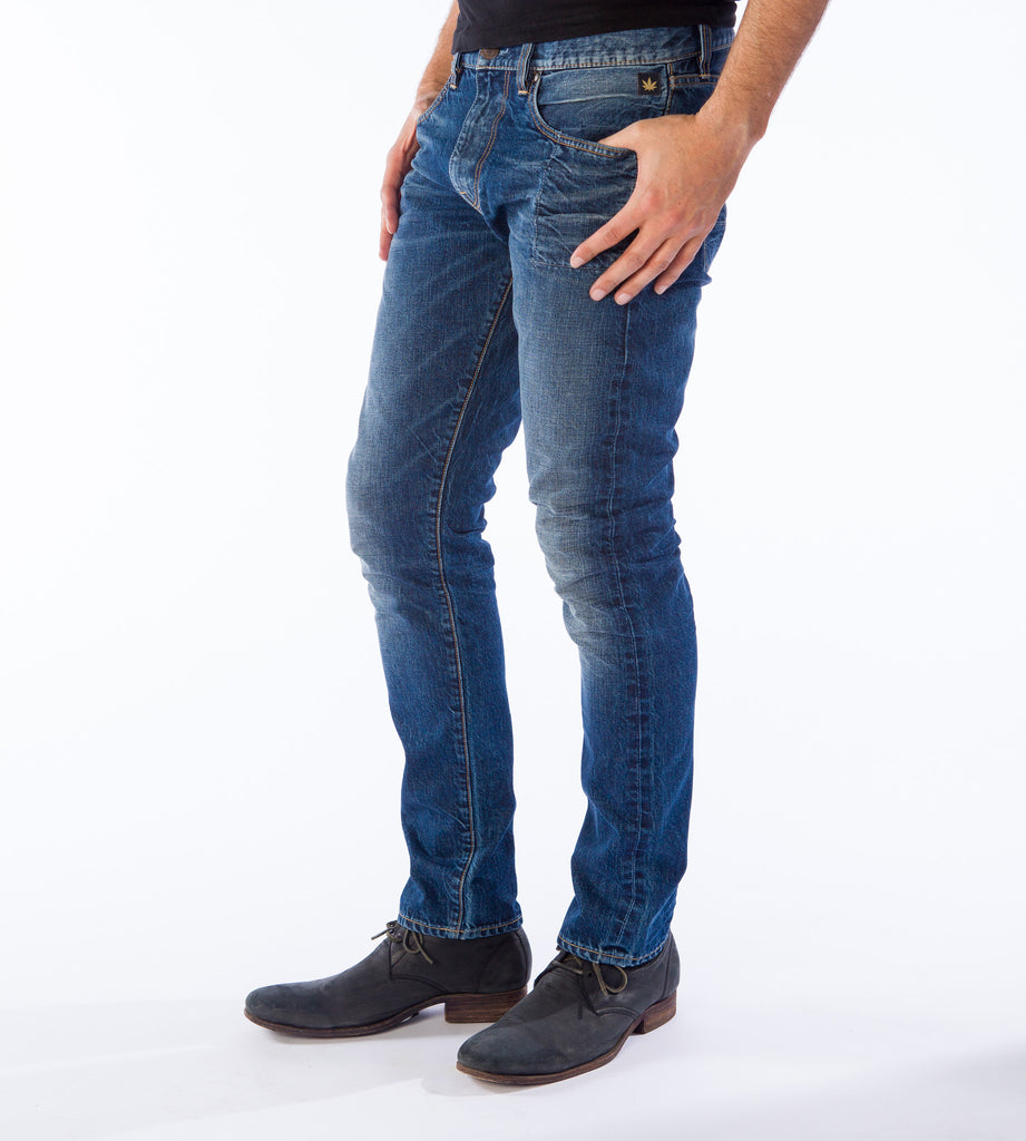 Side profile shot of HempBlue Vintage medium blue hemp blend jeans on a man with blue shoes